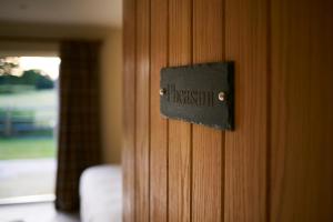 una puerta de madera con un cartel que diga hospital en The Three Chimneys Country Pub, en Biddenden