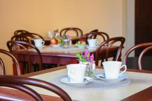 a table with cups and saucers on top of it at Willa Home in Ciechocinek