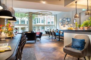 een restaurant met een lange tafel en stoelen bij Hotel Die Port van Cleve in Amsterdam