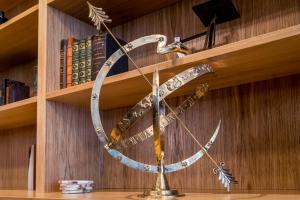 a large metal clock on a shelf with books at Hotel Die Port van Cleve in Amsterdam
