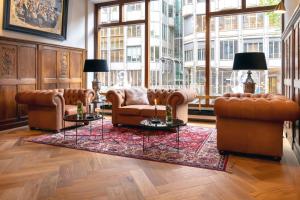 a living room with two couches and a rug at Hotel Die Port van Cleve in Amsterdam