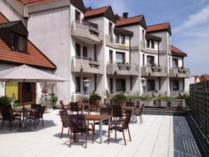 an outdoor patio with tables and chairs in front of a building at Hotel Post Viernheim UG in Viernheim