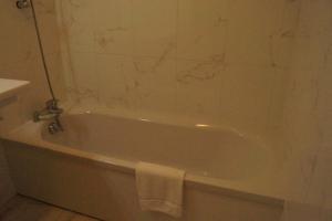 a white bath tub in a bathroom with a marble wall at Résidence Villa Tyrrenia in Macinaggio