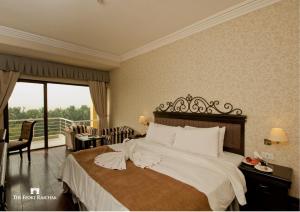 
a hotel room with a large bed and a large window at The Ffort Raichak in Raichak

