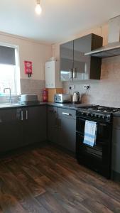 a kitchen with a black stove and a sink at Elmfield Court in Bordon