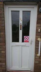 a white door with a no smoking sign on it at Elmfield Court in Bordon