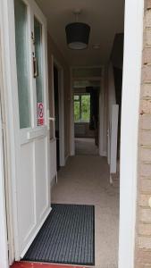 a hallway of a house with a door and a rug at Elmfield Court in Bordon