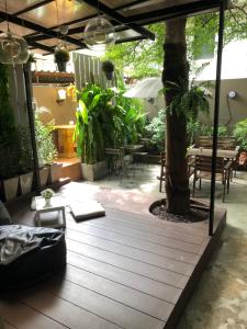 un patio con un árbol, una mesa y sillas en VX The Fifty, en Bangkok