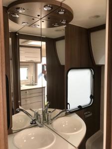 ein Badezimmer mit zwei Waschbecken und einem großen Spiegel in der Unterkunft Erlebniscamping Lausitz - Campingplatz Ortrand / Camping Dresden in Ortrand