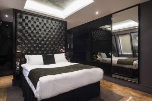 a bedroom with a large bed and a large mirror at Le Monde Hotel in Edinburgh