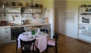 eine Küche mit einem Tisch mit einer rosa Tischdecke in der Unterkunft Aisching in Gstadt am Chiemsee
