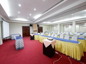 a conference room with tables and chairs and a podium at RedDoorz Plus @ Singosari Raya in Semarang