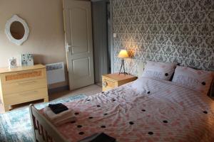 a bedroom with a bed and a dresser with a lamp at Cute Gite family Aucey Mont Saint Michel in Aucey-la-Plaine