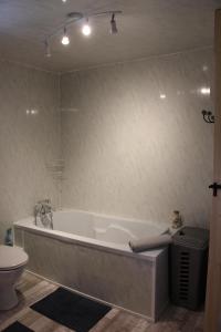 a white bath tub in a bathroom with a toilet at Cute Gite family Aucey Mont Saint Michel in Aucey-la-Plaine