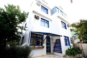 una casa blanca con escaleras azules delante en 18 Children B&B, en Sanzhi