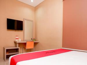 a bedroom with a bed and a desk with a mirror at RedDoorz near Java Supermall Semarang in Semarang