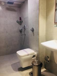 a bathroom with a toilet and a sink at juSTa Rangers Munnar in Munnar