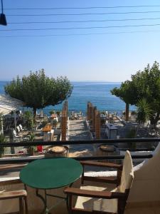 balcón con mesa, sillas y vistas al océano en romanza rooms, en Poulithra