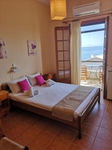 1 dormitorio con 1 cama grande y vistas al océano en romanza rooms, en Poulithra