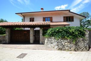 a house with a stone wall and a garage at Gaber B&B in Gabrovizza San Primo +6 photos