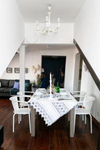 una mesa de comedor blanca con sillas blancas en la sala de estar. en Casa da Baixa, Renovated Beautiful 2 Bedroom Downtown Apartment, en Lisboa