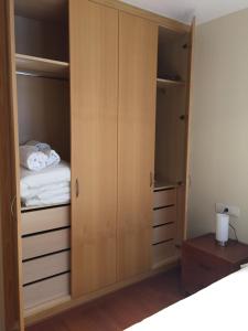 a closet with wooden cabinets and a bed at P&C Areny in Canillo