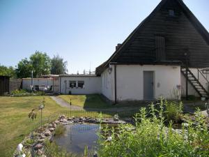 a barn with a pond in front of a yard at Reethaus Natalie in Korswandt