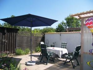a patio with a table and chairs and an umbrella at Reethaus Natalie in Korswandt