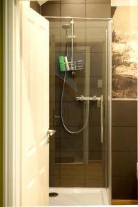 オーバーヴェーゼルにあるMomerooms – Appartement am Momeringのバスルーム(ガラスドア付きのシャワー付)