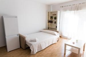 アリカンテにあるCasanova Apartment - Shopping and beachの白いベッドルーム(ベッド1台、テーブル付)