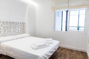 una camera bianca con un letto e asciugamani di Amazing Sea Views with AC two min beach ad Alicante