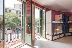 a room with a balcony with bunk beds at No Limit Hostel Graffiti in Barcelona