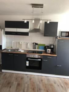 a kitchen with black cabinets and a stove top oven at Apartments Stadtmauer in Northeim