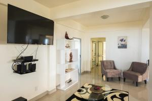 a living room with a tv and two chairs and a table at Mai'i Villa Apartment - 1 in Titikaweka