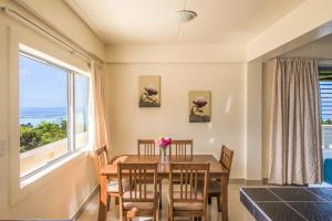 a dining room with a table and chairs and a large window at Mai'i Villa Apartment - 1 in Titikaweka