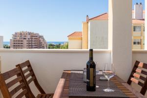 ポルティマンにあるBúzios ASAMO Beach Apartmentのワイン1本(テーブルに座ったバルコニー付)