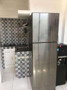 a stainless steel refrigerator in a kitchen with tiles at Rumah Baraka in Yogyakarta