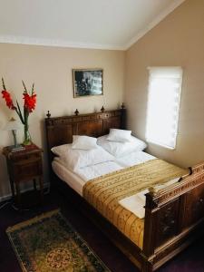 a bedroom with a large bed with white sheets and a window at Willa Sorrento in Szczecin