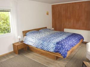 um quarto com uma cama com um edredão azul e uma janela em Ferienwohnung Brigid em Uhldingen-Mühlhofen