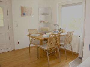 ein Esszimmer mit einem Tisch, Stühlen und einem Fenster in der Unterkunft Ferienwohnung Brigid in Uhldingen-Mühlhofen