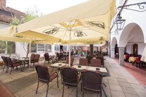 a patio with tables and chairs and umbrellas at Guesthouse Stari Mayr in Kranj