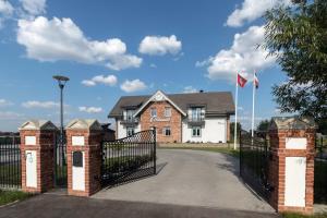 a house with a gate in front of it at Melnmuižė in Karklė