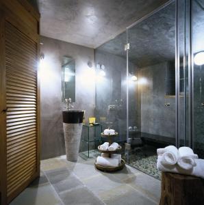 a bathroom with a shower and a sink and towels at 5 Senses in Dikorfo