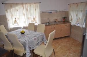 eine Küche mit einem Tisch, Stühlen und einem Waschbecken in der Unterkunft Casa Diu in Avrig