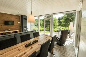 uma sala de jantar com uma mesa de madeira e cadeiras em Ferienhaus Lichtung em Ruhla