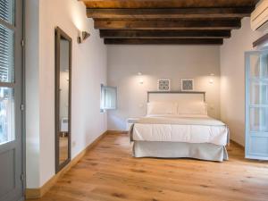 a bedroom with a bed and a wooden floor at Aldaba Apartamentos in Toledo