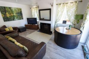 ein Wohnzimmer mit Sofa und Tisch in der Unterkunft Lincoln Holiday Retreat Cottage with Private Hot Tub in Lincoln