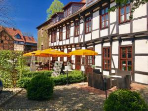 ein Gebäude mit gelben Sonnenschirmen davor in der Unterkunft Halberstädter Hof in Halberstadt