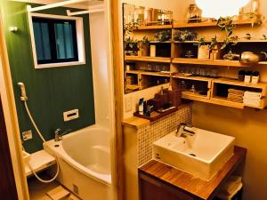 a bathroom with a sink and a toilet and a tub at Villa yamato in Kumamoto
