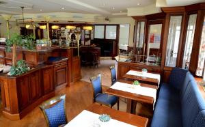 a restaurant with tables and chairs and a bar at Hotel Kruse Zum Hollotal in Neuenkirchen-Vörden